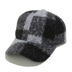 Close-up of a black and gray plaid baseball cap in thick textured sherpa wool fabric
