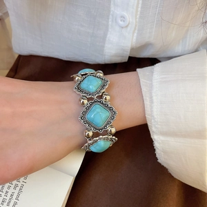 Detail view of vintage acrylic geometric bracelet with turquoise blue stones and silver beads