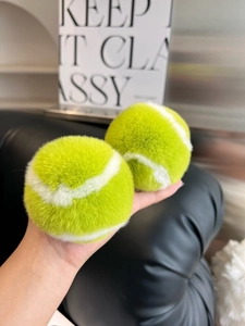 Detailed close-up of fluffy neon yellow tennis ball keychain with soft plush faux fur texture
