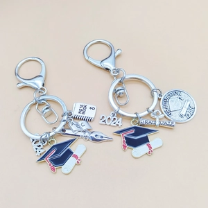 Detailed silver graduation keychains with 2024 charm, cap, and diploma enamel pendants