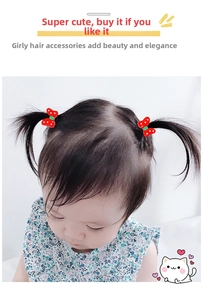 Detail of a young girl wearing two red polka dot bow hair clips on her pigtails