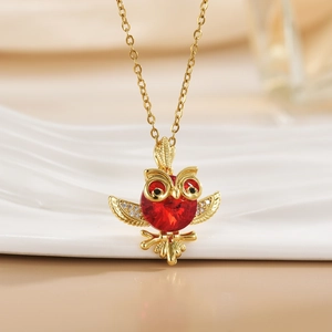 Golden owl pendant necklace with red faceted gemstone and sparkling crystal accents