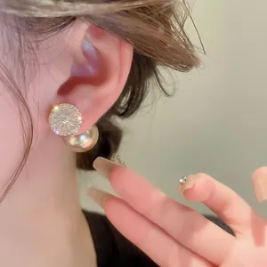 Gold-plated pearl earrings with cubic zirconia, worn by a model in a French chic style