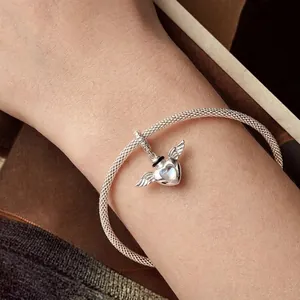S925 sterling silver heart wings charm on a woven bracelet worn on a female wrist