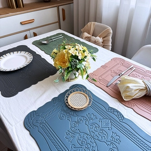 Close-up of European retro embossed leather placemats in green, grey, pink, and blue