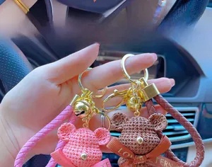 Detail of pink and brown resin bears with knitted texture and golden metal keyrings