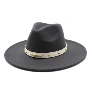 Close-up of dark grey wool felt fedora featuring cream band with gold metal rivets