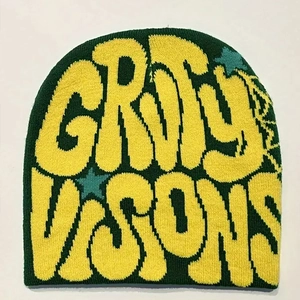 Detailed knit texture of dark green beanie with yellow letters and blue stars