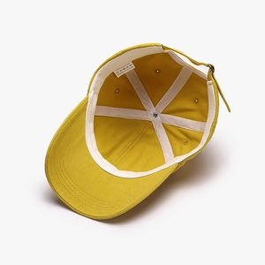 Inside view of mustard yellow cotton baseball cap showing stitching and sweatband details