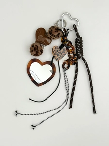 Close-up of heart-shaped keychain with leopard print fur and portable vanity mirror charm
