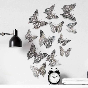 Detail of silver hollow-out butterfly wall stickers on white wall with home decor