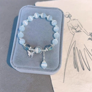 Détail du bracelet en perles d'opale bleu clair avec papillon en zircon sur velours