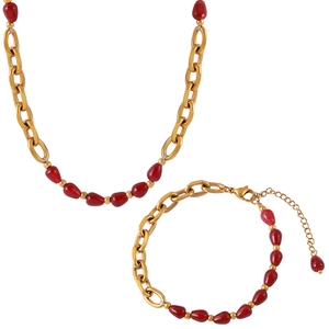 Elegant gold plated necklace and bracelet set with red agate garnet beads on white background