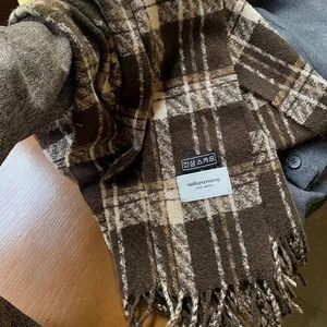 Detail of plaid scarf featuring brown vintage patterns and fine tassel texture