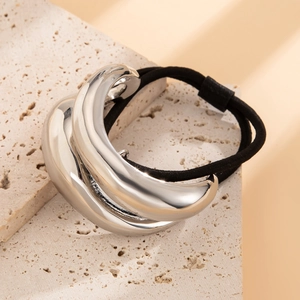 Close-up of a black elastic hair tie with a sleek C-shaped silver metal curved ornament