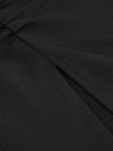 Detail of high-slit hem and sewing craft on black long-sleeve evening dress