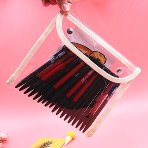 Transparent PVC pencil case with snap closure holding pens and cartoon cards