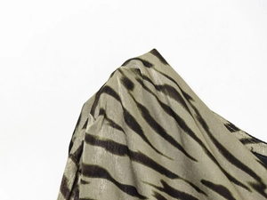 Makroaufnahme von olivgrünem Zebra-Stoff mit seidiger Textur und glänzendem Finish