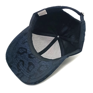 Detailansicht der Innenseite der schwarzen Baseballkappe mit Polyester-Etikett und Gurt
