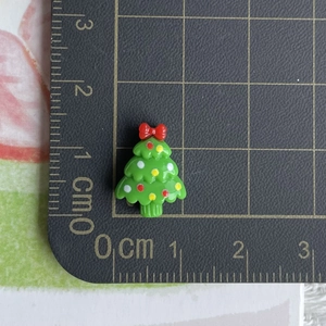 Detailed view of a mini resin Christmas tree charm on a grid mat showing 2cm height