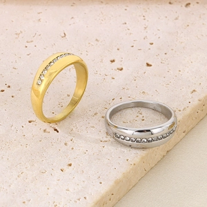 Detailed view of gold and silver minimalist rings with inlaid rhinestones on stone background