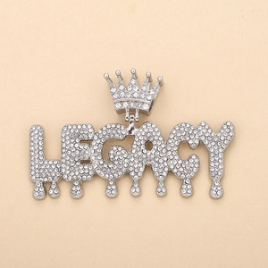 Detail of silver LEGACY letter pendant with crown and melting drip effect in iced-out stones
