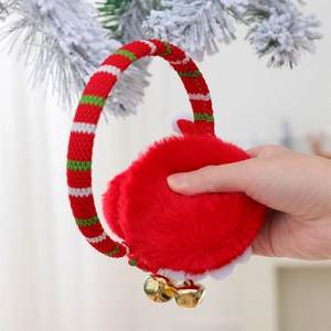 Detail of red plush Christmas earmuffs with golden bells and festive striped headband