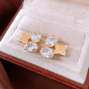 Exquisite 18K vergoldete Blumenohrstecker mit ovalem Zirkon in einer Schmuckschatulle