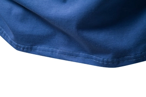 Close-up of double-needle stitching and knit texture on the blue cotton T-shirt hem