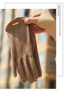 Detailed view of winter suede gloves in dark coffee with golden fashion metal plaque