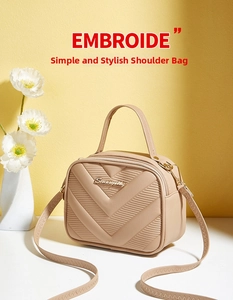 Detail of beige V-quilted small square bag with metal logo and refined handle texture
