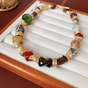 Close-up of vintage flower ceramic beaded necklace with colorful beads and golden toggle