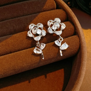 Gros plan de boucles d'oreilles fleurs en argent et zircon sur boîte en velours