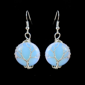 Macro shot of handmade tree of life wire-wrapped earrings with blue crystal stones