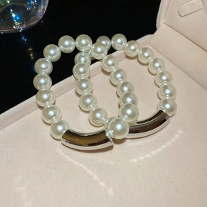 Close-up of pearl bracelets with silver metal tube detail in a pink jewelry box