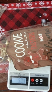 Close-up of wooden gingerbread man welcome sign with Cookie Tasters text on scale