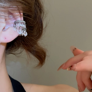Gros plan d'un protège-oreille avec pampilles en zircon brillant sur l'oreille du mannequin