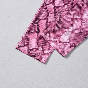 Dettaglio ravvicinato di tessuto rosa pitonato con trama elastica e cucitura overlock