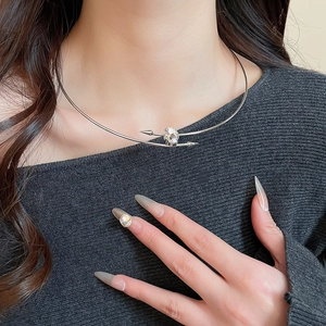 Macro shot of a silver rhinestone-inlaid oval collar necklace on a female model