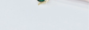 Detail of emerald gemstone pendant with golden diamond-studded curve on titanium steel necklace