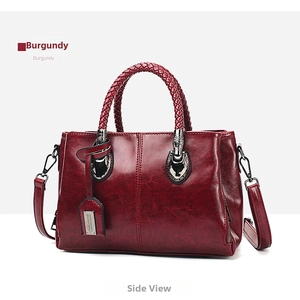 Micro side view of vintage burgundy Boston bag with woven handles and silver hardware