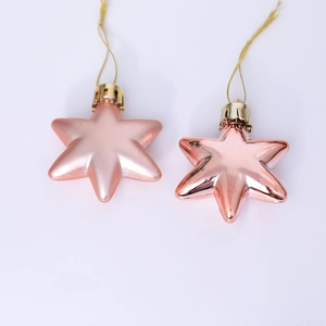 Detail of rose gold Christmas star ornaments with matte and glossy finishes
