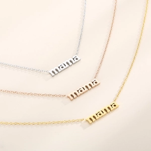 Three-tone display of 'mama' pendant necklaces in silver, gold, and rose gold finish