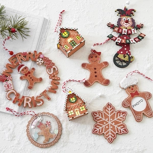Assorted wooden Christmas ornaments featuring glowing houses and gingerbread men decor