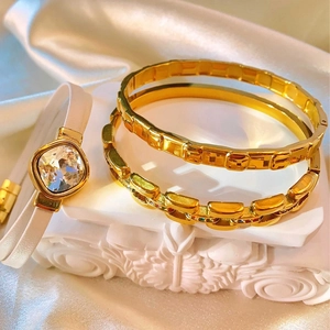 Elegant gold bracelet set with square crystal on white silk background luxury style