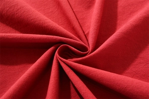 Close-up of red washed cotton tablecloth showing soft texture and natural fabric folds