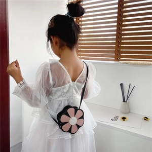 Detail of a floral crossbody bag in black and pink with a delicate white center