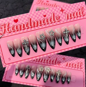 Détail d'ongles ombrés faits main avec croix argentées et étoiles strass étincelantes
