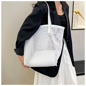 Modern white mesh tote bag shown on model in a minimalist interior setting