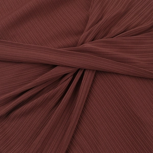 Détail de maille côtelée marron rougeâtre présentant un design de nœud torsadé chic